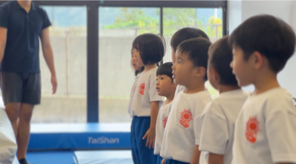 SBCスポーツ教室の体操体幹クラスでコーチの説明を聞く子どもたち